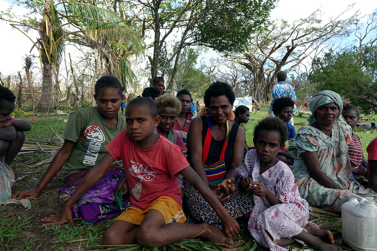 Nai with three of her six children Marie (14, green t-shirt), Samuel (11, red t-shirt) and Wendy (5, white and pink dress) at a World Vision distribution of tarps, mosquito nets, jerry cans and blankets.