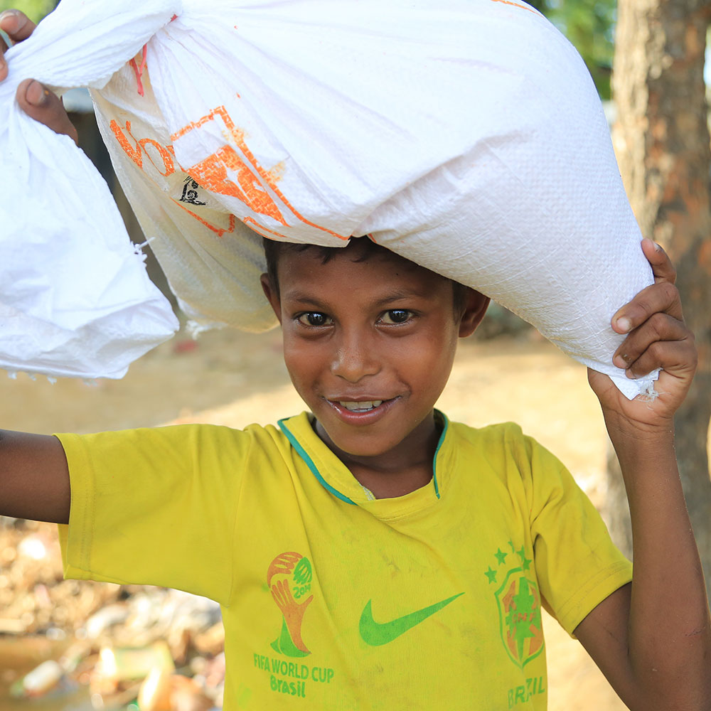Rofi and family receiving their two-week food supply at a World Vision distribution site