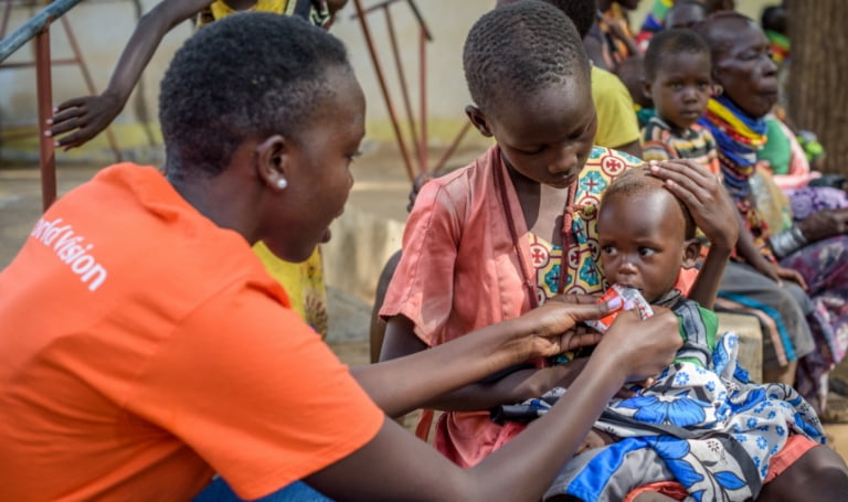 Emergency worker feeding nutritional paste to a malnourished child