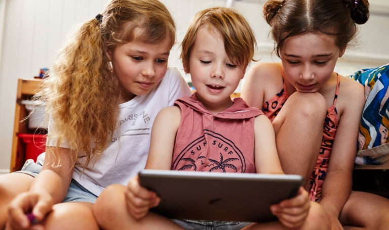 3 Australian children sitting around an ipad