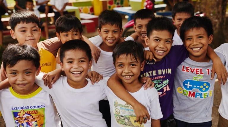 Group of children linking arms smiling at the camera