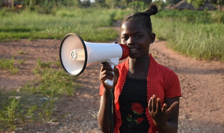 Girl holding a loud speaker in a paddock
