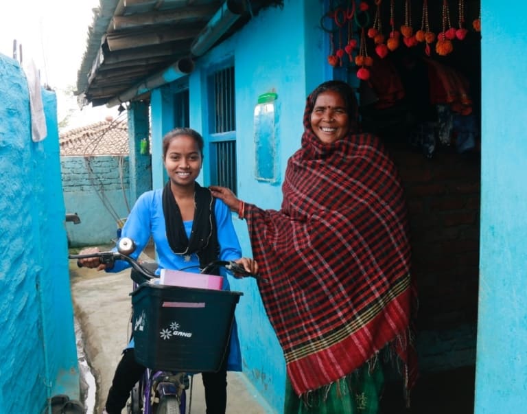 Woman with her daughter who is riding a bike