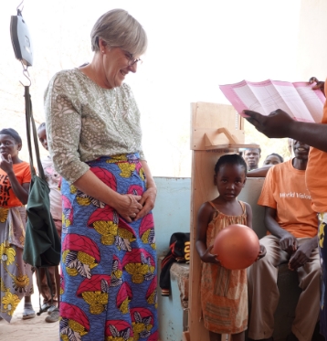 A lady helping taking measurements for a young child in Zambia