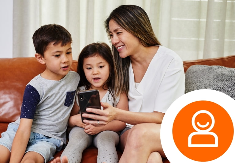 Family sitting on the couch looking at a mobile phone