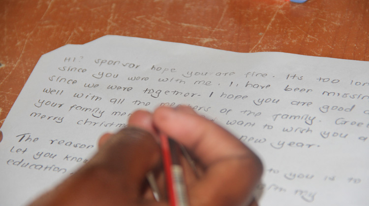 Child writing a letter to their sponsor