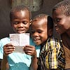 Smiling children read letter from sponsor