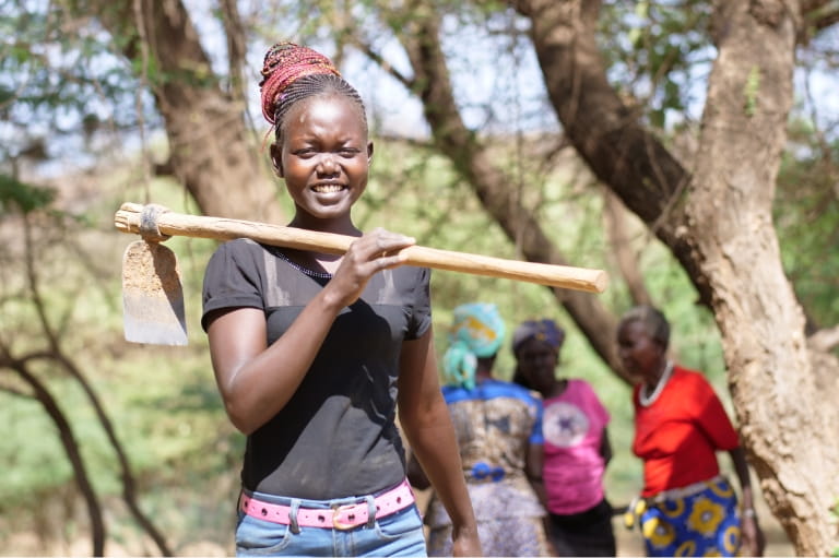 Girl holding a hoe smiling