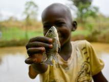 Young Mopao shows off one of the fingerlings found swimming in the fish farms of South Sudan.