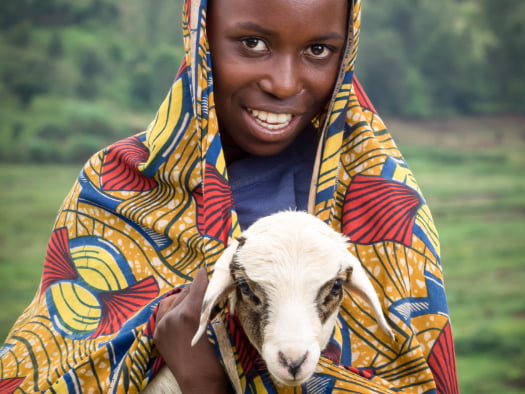 Sarah with a baby lamb that will help provide wool for clothing in north-eastern Burundi.