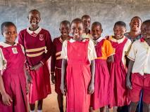 Sherinah (centre) is surrounded by her fellow students, all members of the Peace Road and Vision Club committee at her school in Uganda.