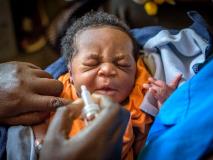 An infant receives an oral polio immunisation at a health centre in Uganda.