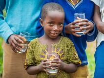 As a little brother to a sponsored child, Emmanuel and his community benefit from clean drinking water supplied by a World Vision tap near their home in Kisaro, Rwanda.