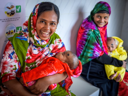 Hena holds her son at a community clinic in Bangladesh where children are immunised and mothers can participate in nutrition classes.