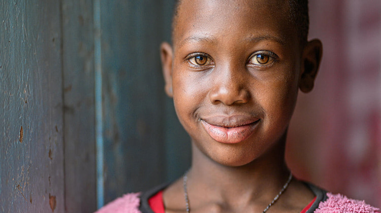 The bright-eyed face of an 11-year-old girl from Tanzania.