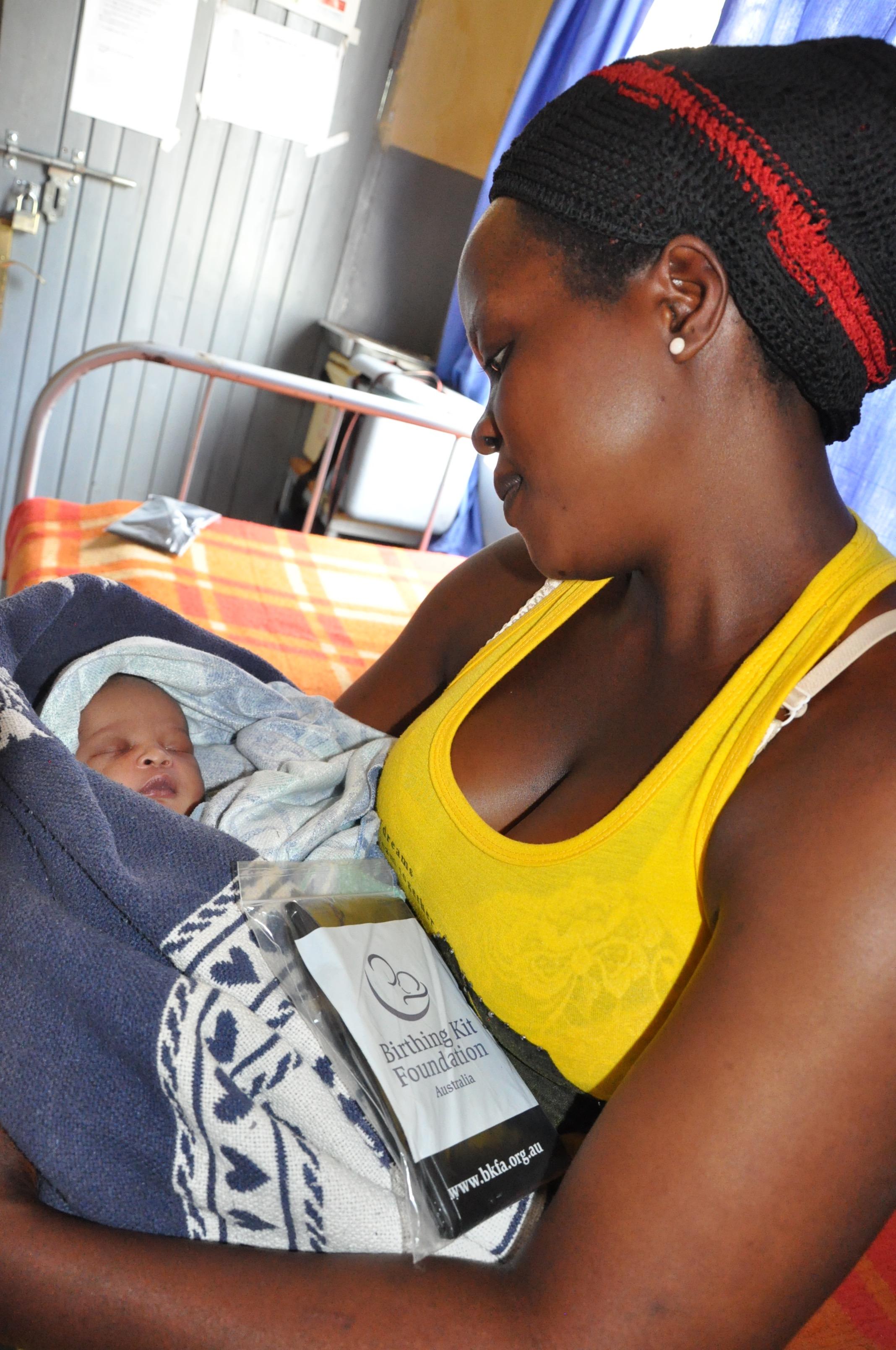 Ugandan woman and child with clean birthing kit