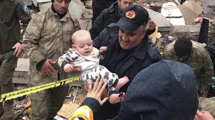 Child being pulled out of the rubble after earthquake in Syria